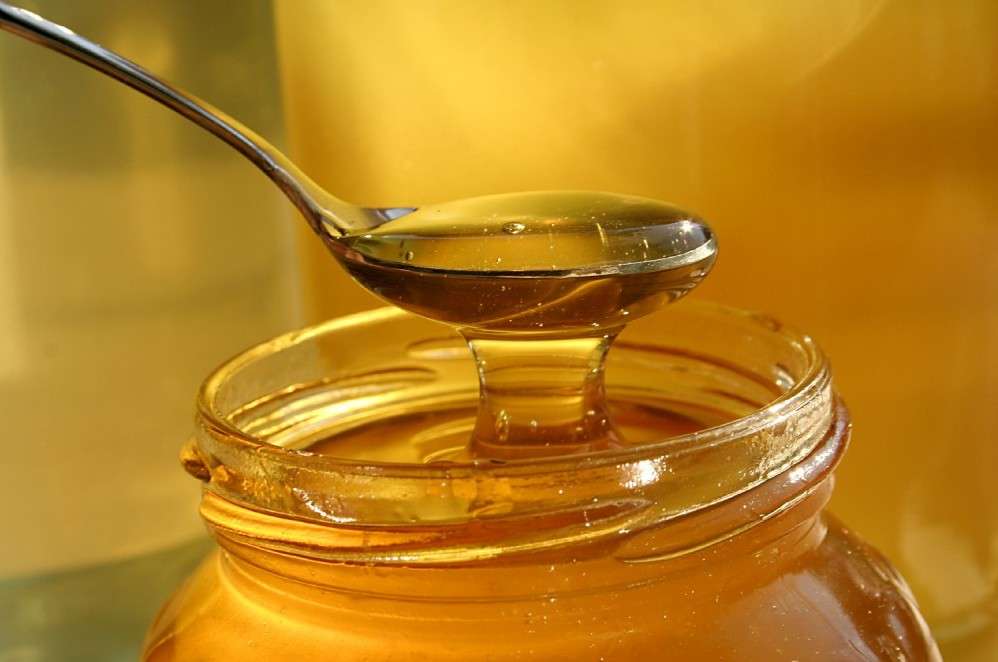 Honey in jar and a spoon