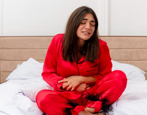 beautiful women in red dress suffering with Period pain